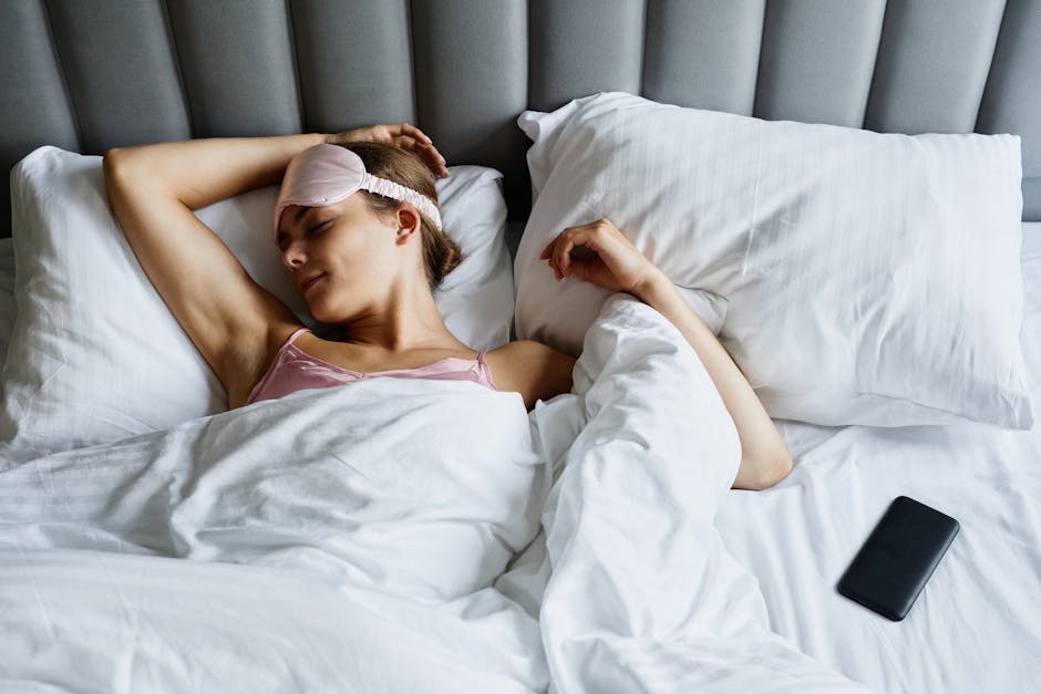 Een persoon die comfortabel slaapt met hoogwaardige slaapproducten zoals een kussen en dekbed.